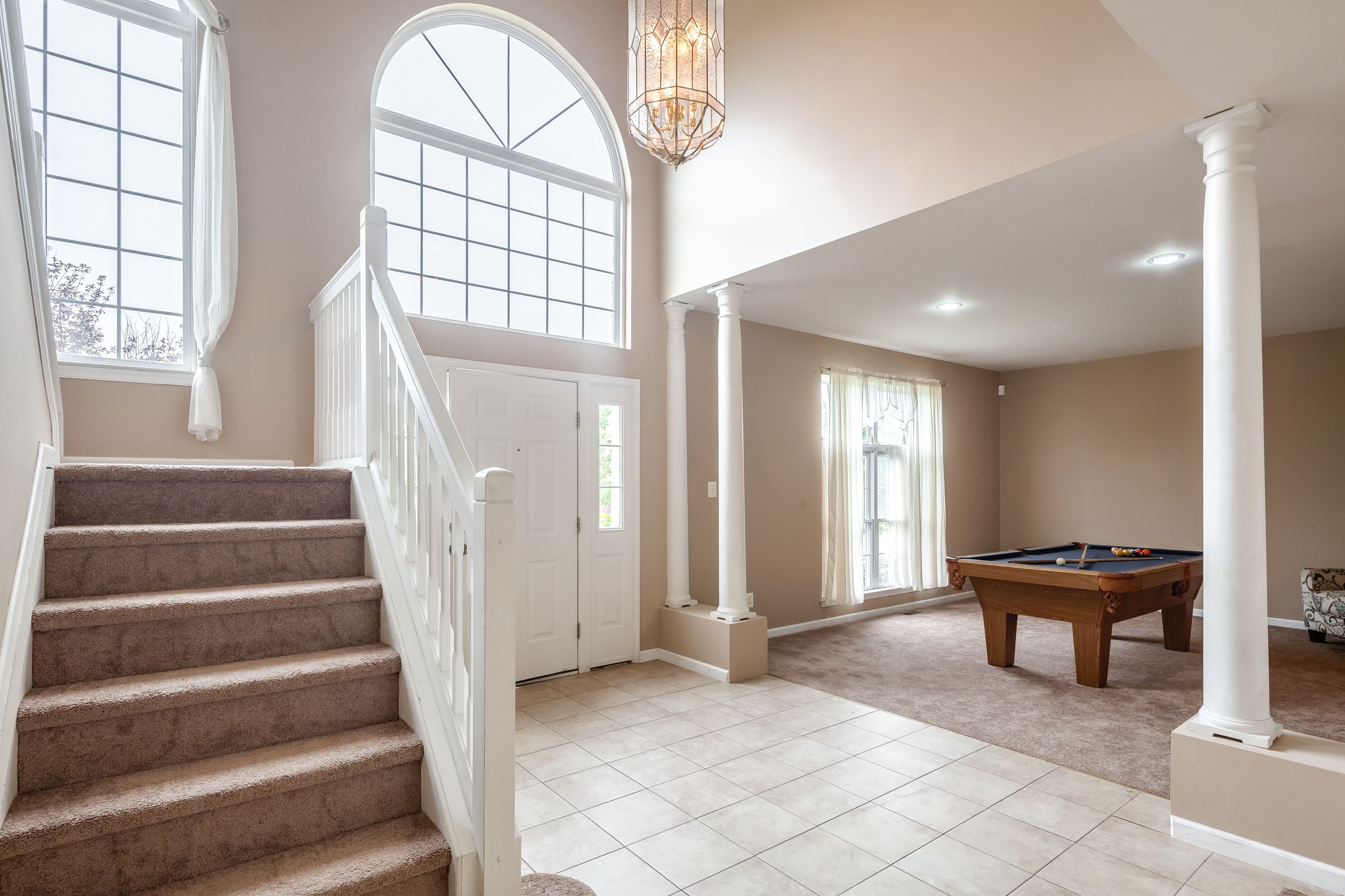 main entrance with chandelier with view of stair case and pool table at Sicklerville Sober Living Home for Women