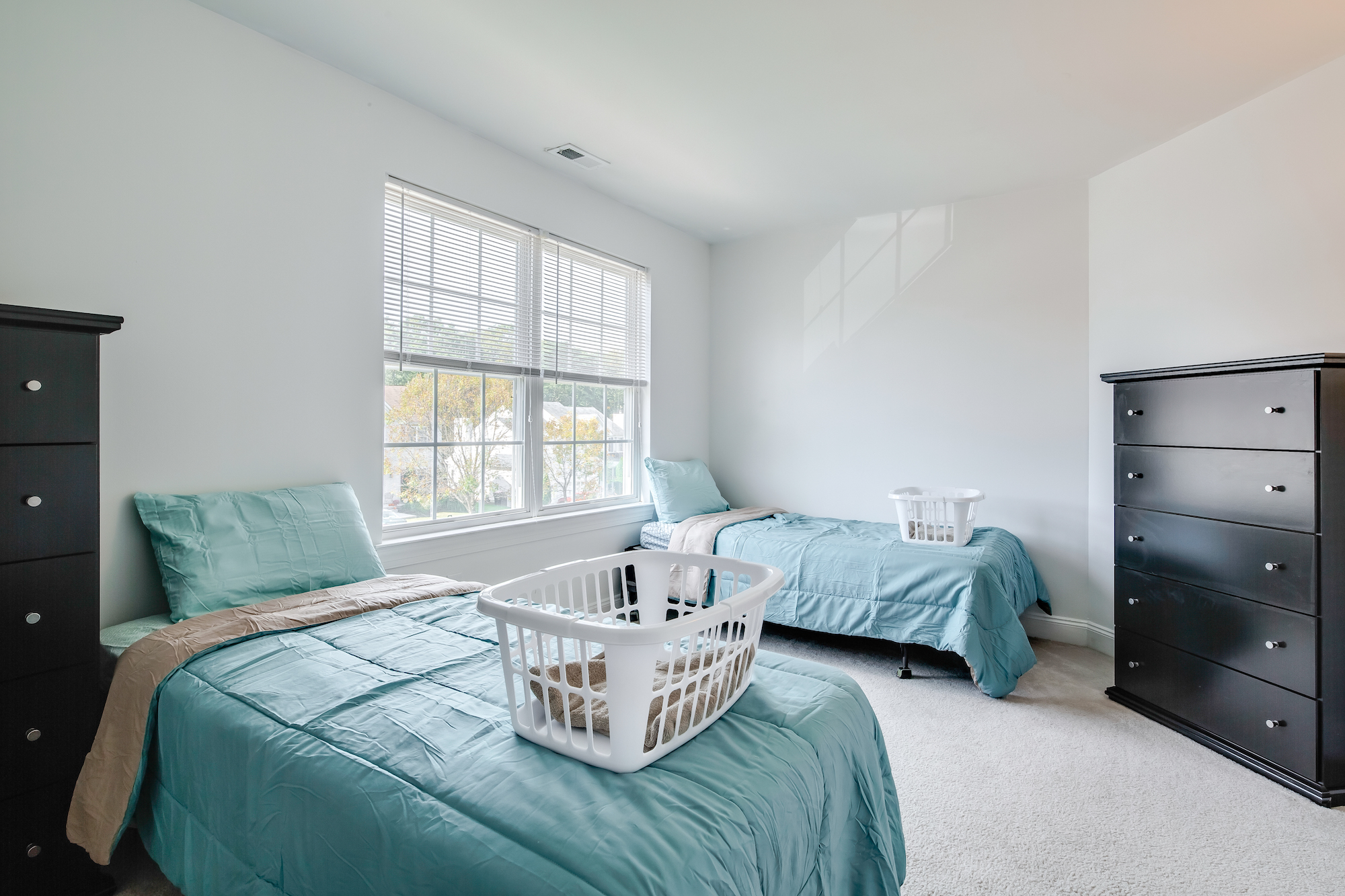 bedroom for two with chest of drawers and windows at Dignity Hall Sober Living Homes