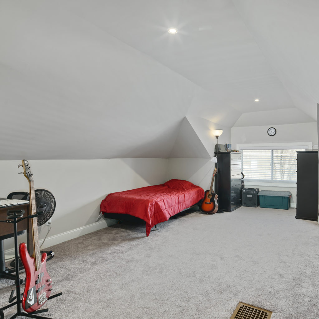 Bedroom with musical instruments and personal belongings along with bed and chested drawers at Full kitchen stylishly designed with seating and updated appliances at Somerdale Sober Living Homes for Men