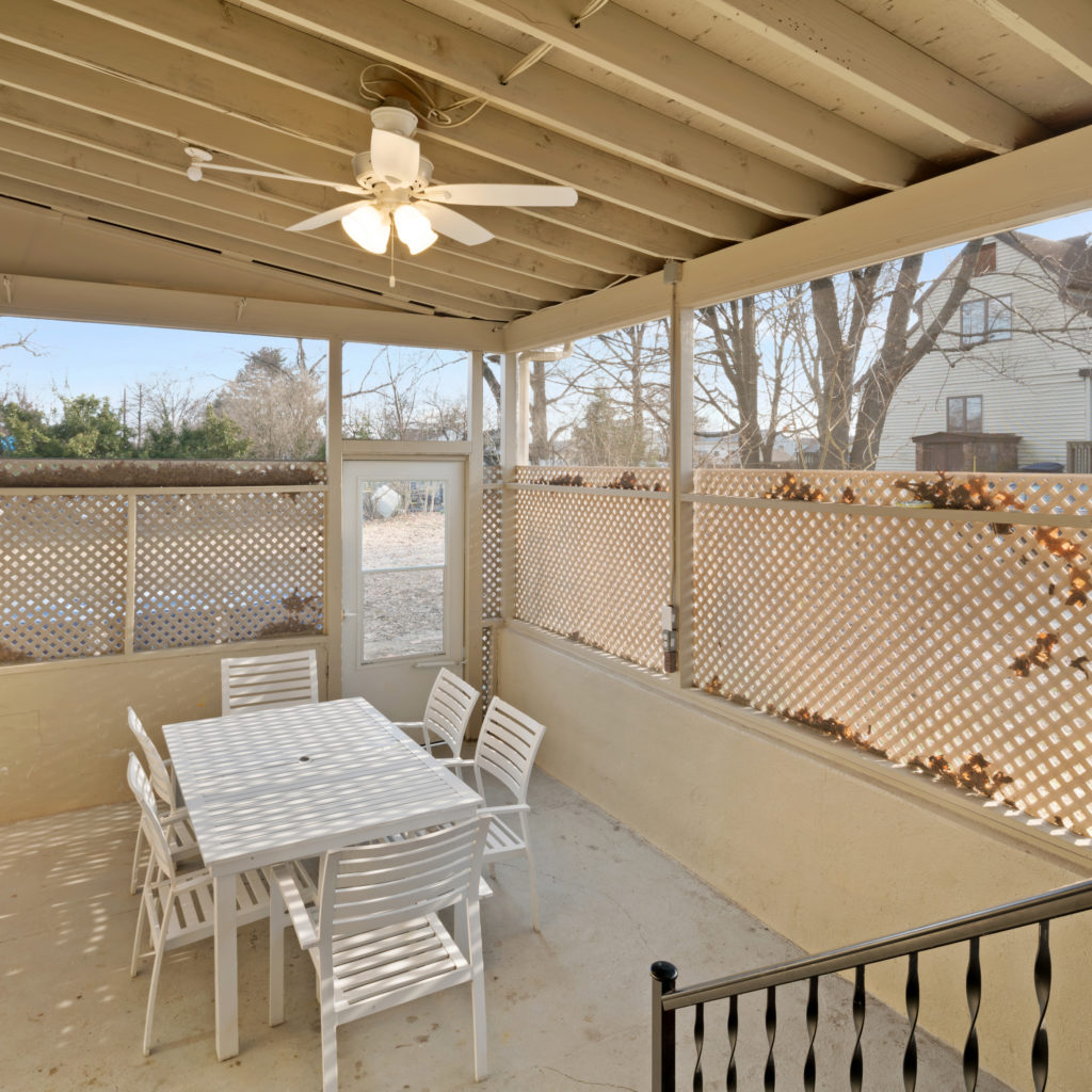 Outdoor porch area with seating and door to yard at Full kitchen stylishly designed with seating and updated appliances at Somerdale Sober Living Homes for Men