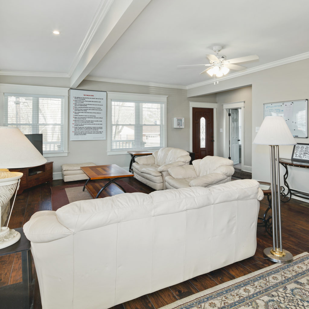 Living room with stylish furniture and lighting with leather seating at Full kitchen stylishly designed with seating and updated appliances at Somerdale Sober Living Homes for Men