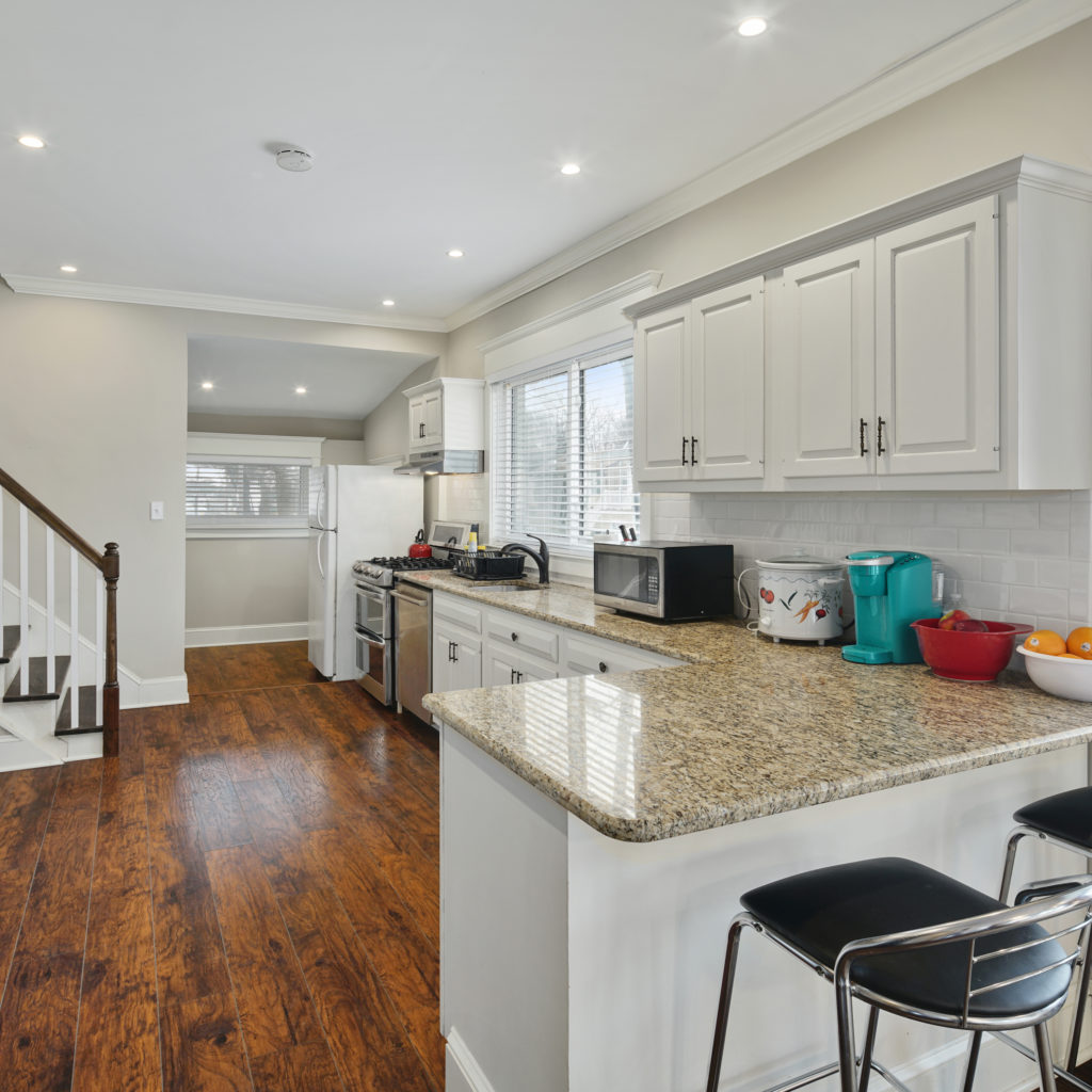 Full kitchen stylishly designed with seating and updated appliances at Somerdale Sober Living Homes for Men