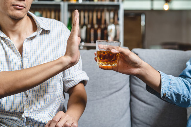 dos and donts of sober living dos and donts of sober living person being offered glass of alcohol but holding up their hand refusing it
