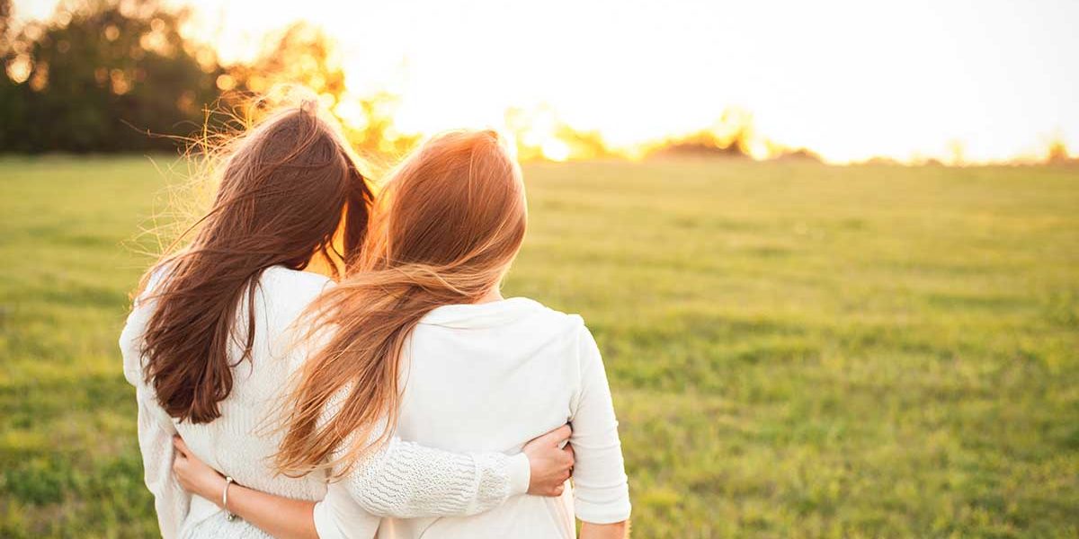 relationships and recovery two women holding in each other in a field showing relationships and recovery