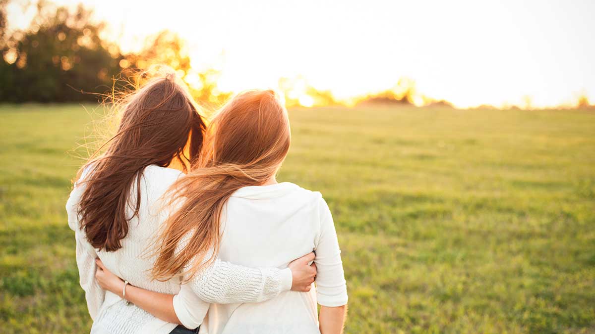 relationships and recovery two women holding in each other in a field showing relationships and recovery